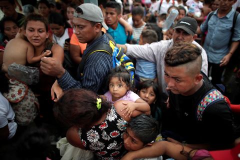 Children of migrants, part of the caravan, on Saturday wait with their parents to apply for asylum in Mexico at a checkpoint in Ciudad Hidalgo, Mexico.