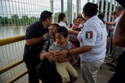 A Honduran migrant mother and her son walk on the bridge after crossing the border between Guatemala and Mexico on Saturday.