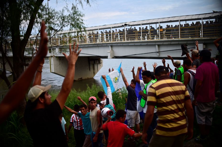 Honduran migrants who have already reached Mexican soil cheer at the rest of the group still waiting to cross at the Guatemala-Mexico border bridge in Ciudad Hidalgo, Mexico, on Saturday, October 20.