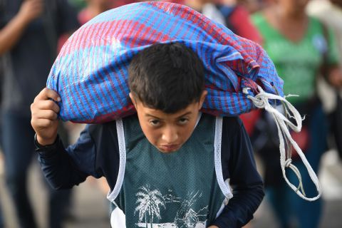 A Honduran migrant boy, part of a caravan heading to the United States, walks on the road linking Ciudad Hidalgo and Tapachula, Chiapas state, Mexico, on Sunday.