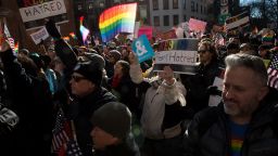 People hold signs and flags at a rally in front of the Stonewall Inn in solidarity with immigrants, asylum seekers, refugees and the LGBT community on February 4, 2017 in New York. 