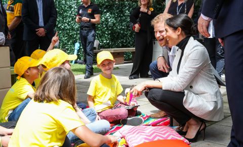Britain's Prince Harry and Meghan, the Duchess of Sussex, talk with schoolchildren in Sydney on Sunday, October 21.