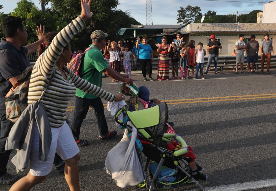 Local residents cheer as a migrant caravan walks into the interior of Mexico after crossing the Guatemalan border.