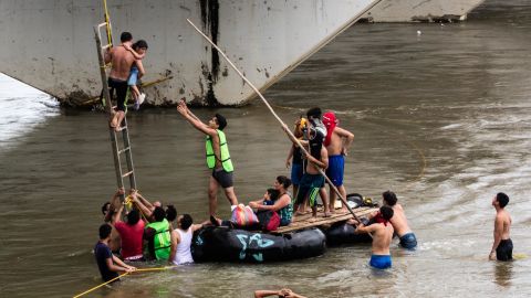 Helpers reach out to Candy as she nears the raft.