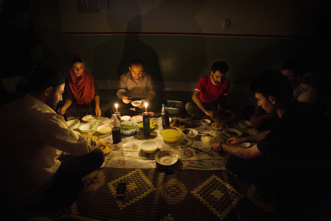 A family in Iraq sits by candlelight due to blackouts caused by the country's infrastructure problems.