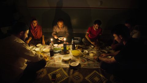 A family in Iraq sits by candlelight due to blackouts caused by the country's infrastructure problems.