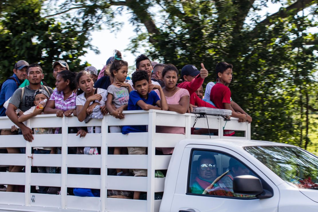 Migrants take a ride on a truck as they head north into Mexico.