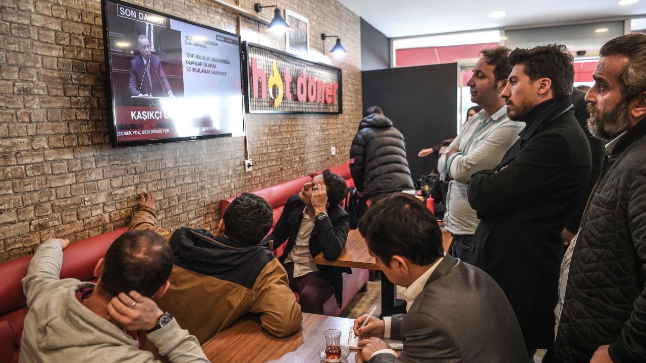 People gather around a TV at an Istanbul cafe to watch Erdogan's speech.