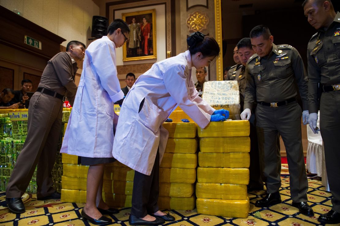 Thai national police chief general Chaktip Chaijinda (second from the right) watches police department chemists inspect seized drugs during a press conference in Bangkok on May 11. Ten million yaba pills made in Myanmar and nearly half a tonne of crystal meth hidden in tea packages was  seized from a convoy in downtown Bangkok, Thai police said. 
