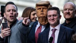 Far-right figurehead Tommy Robinson (2nd R), stands beside a man in a Donald Trump mask as he addresses supporters outside the Old Bailey on October 23.