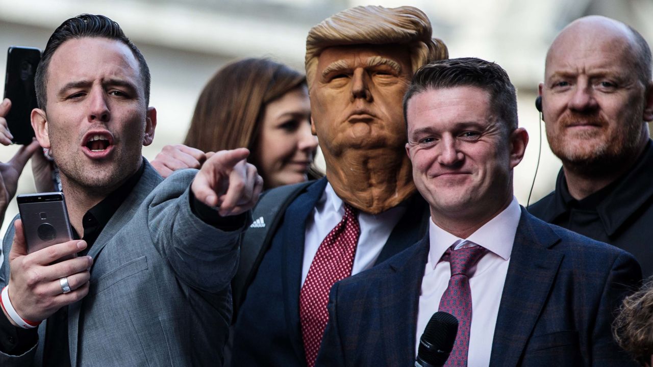Tommy Robinson, second from right, stands next to a man in a Donald Trump mask as he addresses supporters outside London's Old Bailey courthouse on Tuesday.