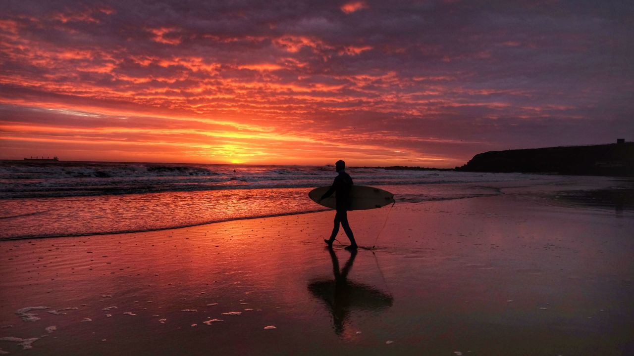 <strong>\North Tyneside, United Kingdom</strong>: A surfer heads toward the North Sea at sunrise in North Tyneside in northern England.