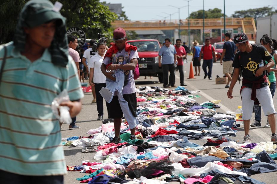Migrants select clothes that have been placed along the road by Mexican citizens. 