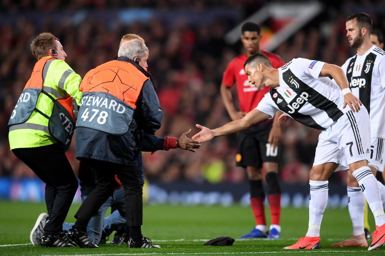 The game was temporarily halted after a fan ran onto the pitch to greet Ronaldo. The Juventus man acknowledges his admirer as stewards try to restrain him. 