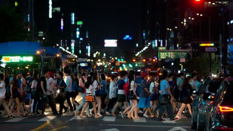 Pedestrians cross a road in the Gangnam district of Seoul. South Korea has some of the longest working hours in the world. 