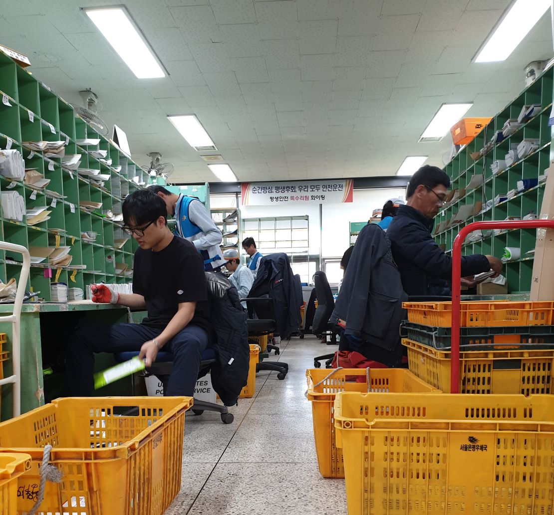 Workers for Korea Post sort packages and letters. The company has faced repeated pressure from workers and the government to reduce employee hours on the job. 
