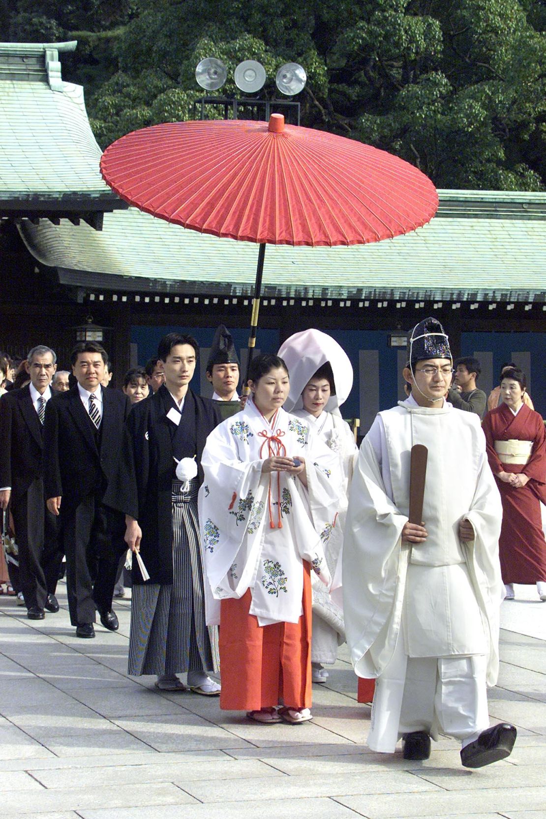 A Shinto priest leads the way of a Shinto wedding at the Meiji shrine. 