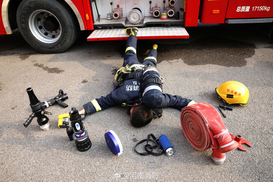 A Henan Fire Department firefighter lies among the tools he uses in his everyday job.