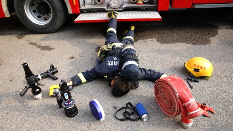 A Henan Fire Department firefighter lies among the tools he uses in his everyday job.