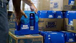 An employee adjusts bottles of Bud Light brand beer at an Anheuser-Busch InBev NV facility during a campaign stop by Senator Tim Kaine, a Democrat from Virginia, not pictured, in Williamsburg, Virginia, U.S., on Wednesday, August 8, 2018. 