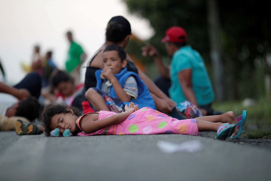 Families rest on a roadside between Mapastepec and Huixtla, Mexico, while traveling with thousands of migrants from Central America in a caravan en route to the United States, on Wednesday, October 24.