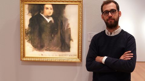 Pierre Fautrel, co-founder of a group that produces art using AI, stands next to "Portrait of Edmond de Belamy," the first work produced by a machine to be sold at auction.