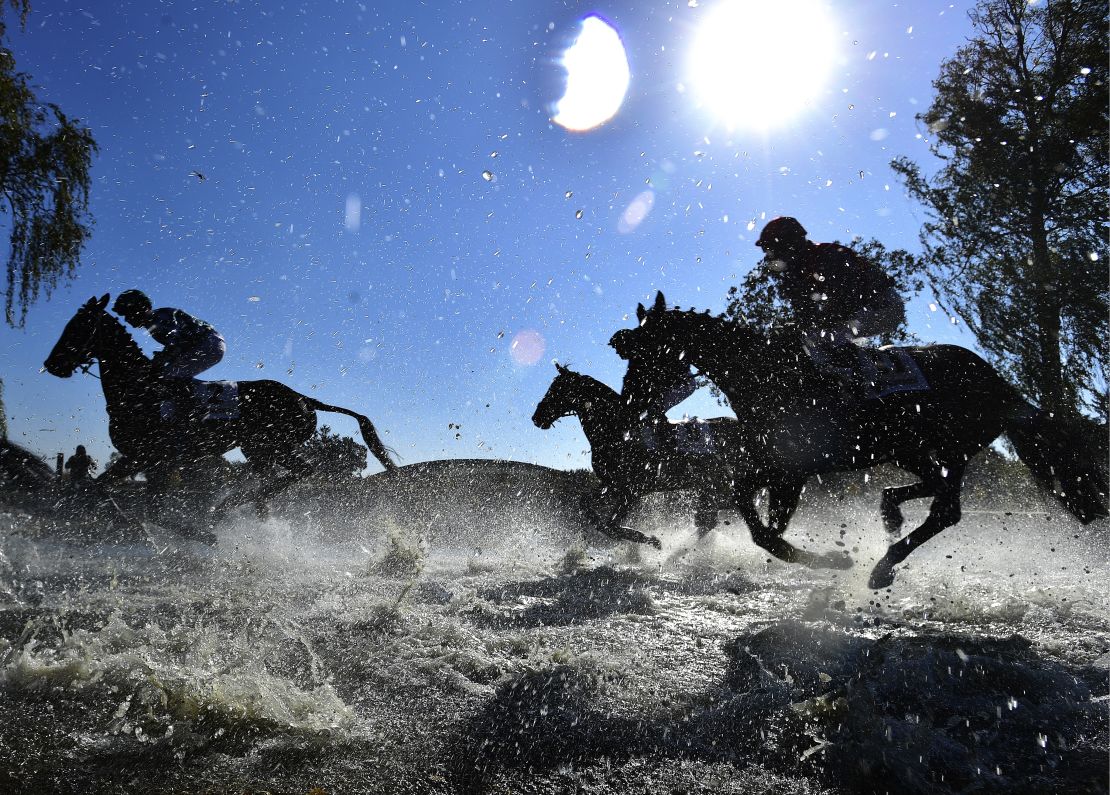 Horses and jockeys compete during the Steeplechase cross country in Pardubice, Czech Republic.