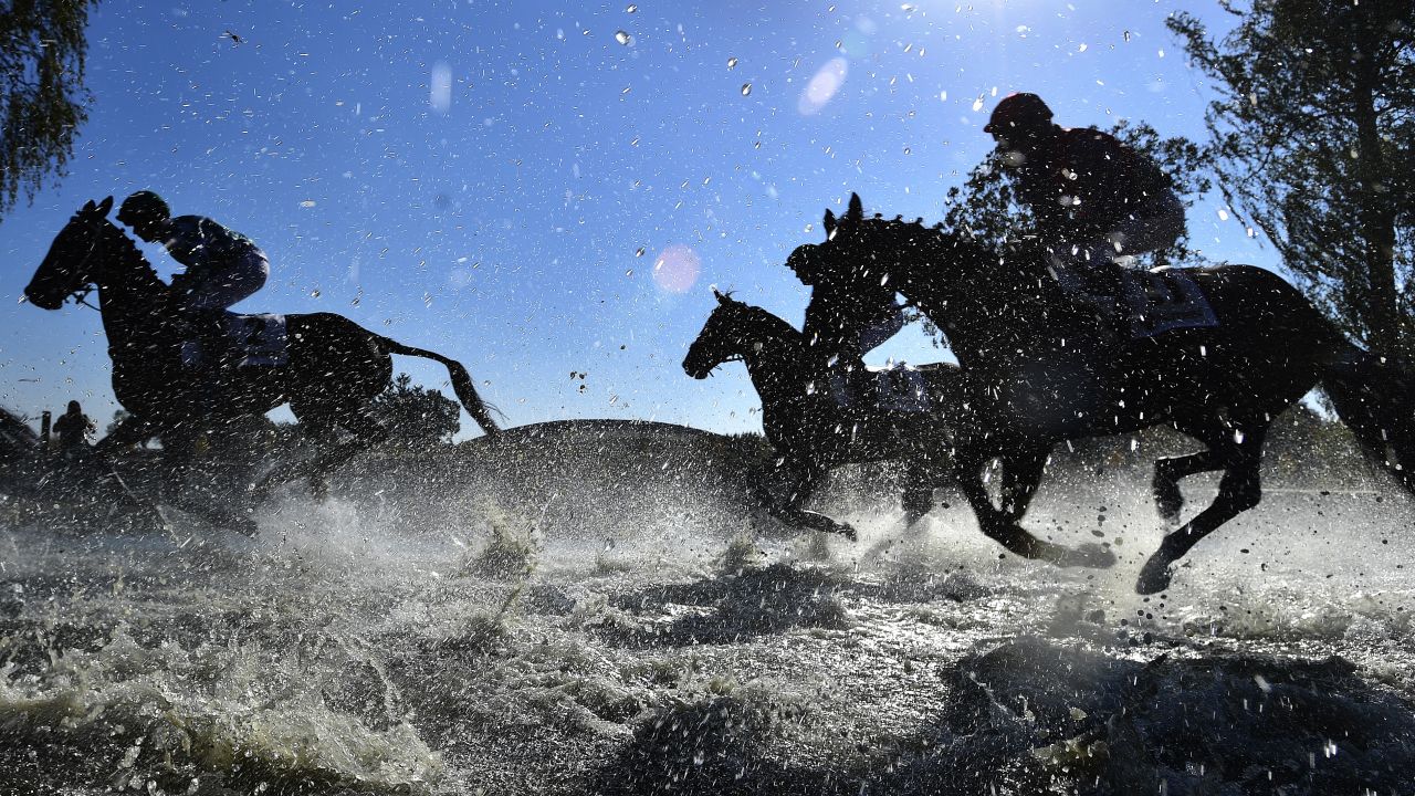 Horses and jockeys compete during the Steeplechase cross country in Pardubice, Czech Republic.