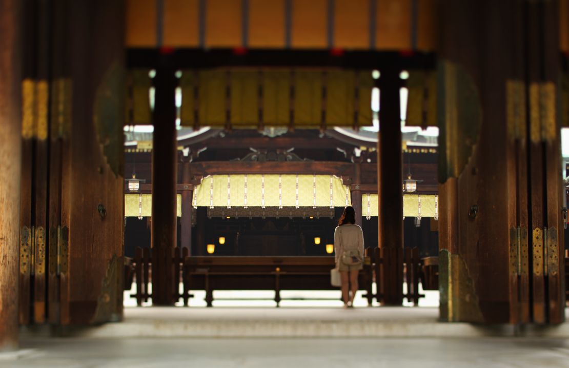 A visitor prays at Meiji shrine in Tokyo.