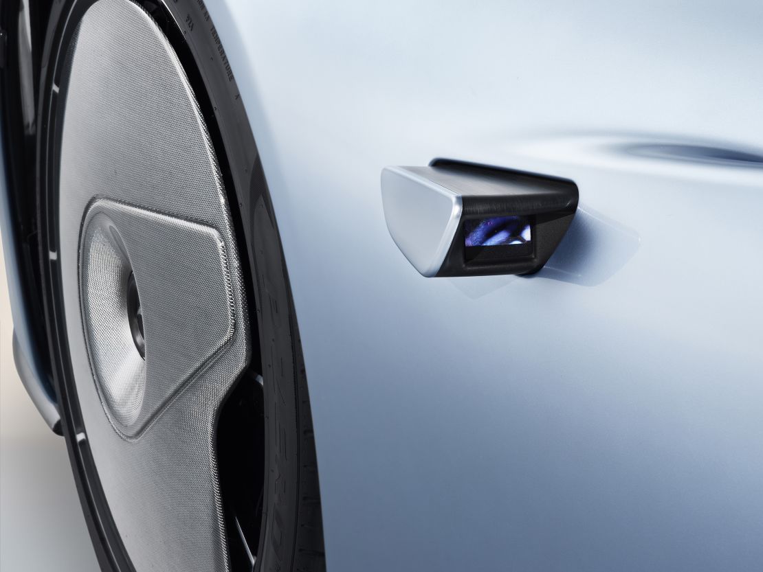 Small video cameras replace side mirrors. The front wheels are covered by stationary shields.