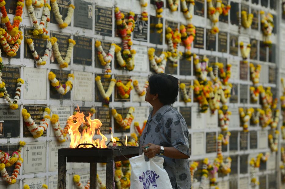 A woman prays near a plaque commemorating relatives on All Souls Day at a cemetery in Mumbai, India, on November 2, 2017. All Souls Day is observed in remembrance of friends and loved ones who passed away.
