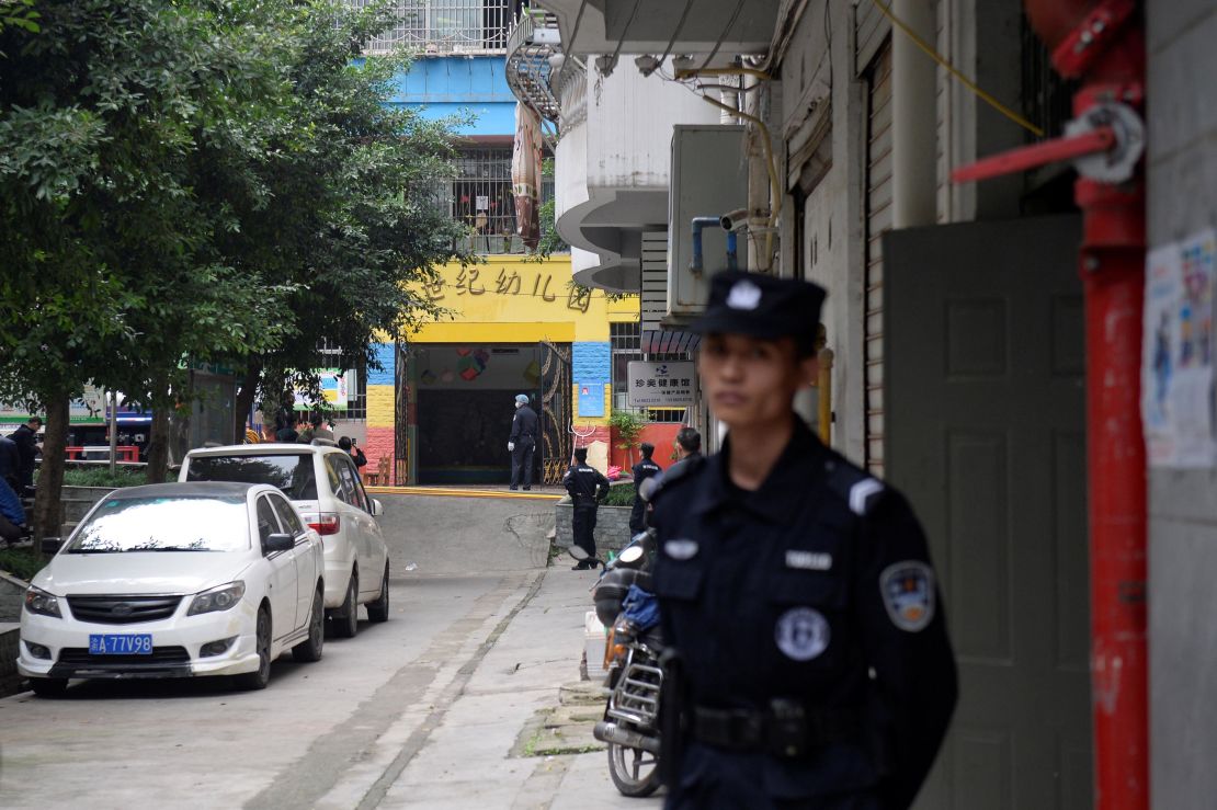 Police officers are seen outside the gate of a kindergarten where a woman armed with a kitchen knife attacked children in Chongqing on October 26.