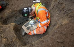 An archaeologist on the project examines a coffin plate at St James's burial ground.