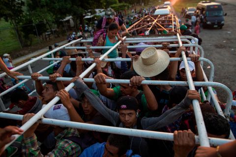 Migrants travel on a cattle truck, as a thousands-strong caravan of Central American migrants slowly makes its way toward the US border, between Pijijiapan and Arriaga, Mexico, on Friday, October 26.