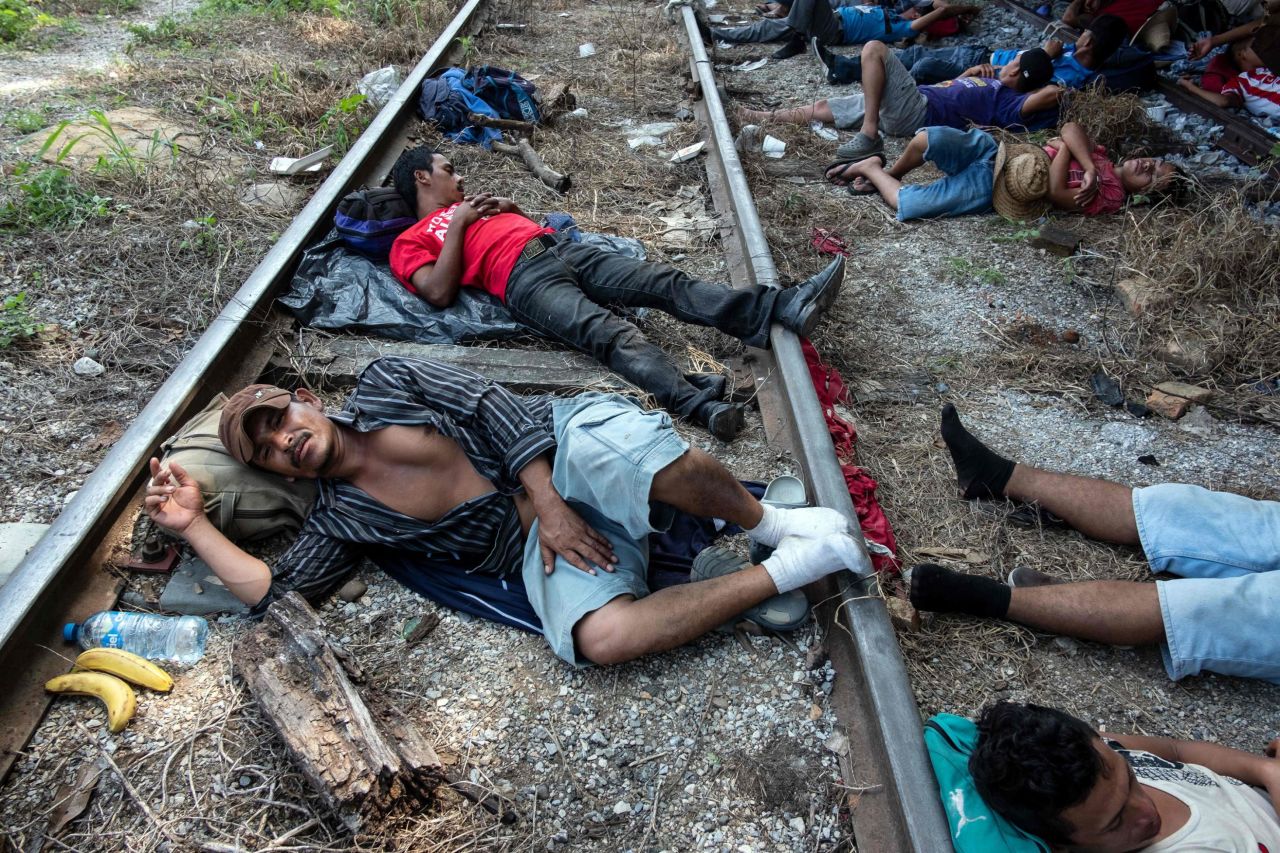 Migrants heading in caravan to the United States rest on the train tracks in Arriaga, Mexico.