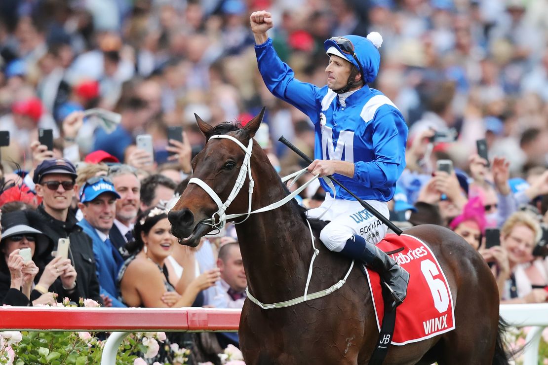 Jockey Hugh Bowman celebrates after guiding Winx to her record fourth Cox Plate at Moonee Valley in Melbourne, her 29th straight victory.