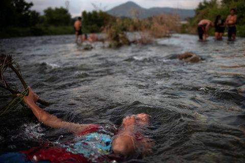 Jensi, a 14 year old migrant girl from Honduras, baths in a fresh water stream as she and others, part of caravan of thousands from Central America en route to the United States, take rest in Pijijiapan, Mexico on October 25.