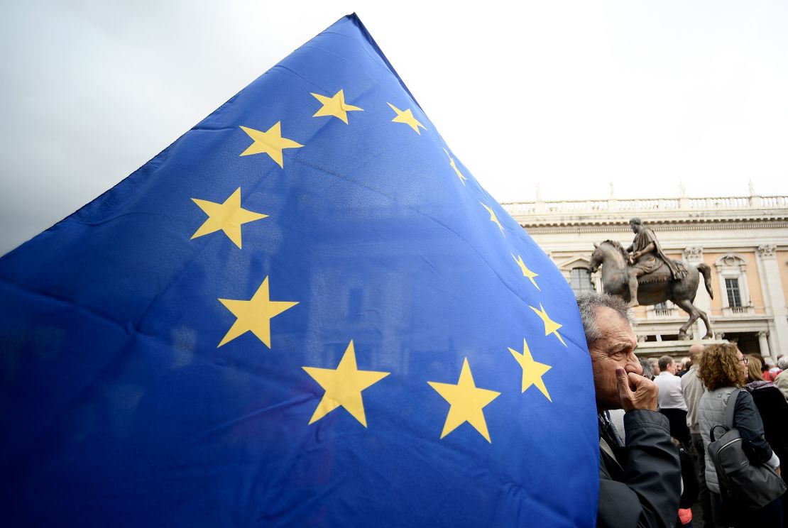 A demonstrator holds an EU flag in Rome's Piazza del Campidoglio during a protest Saturday against decay of the capital under the populist Five Star Movement.