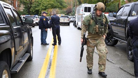 A SWAT police officer and other first responders respond after a gunman opened fire at the synagogue.
