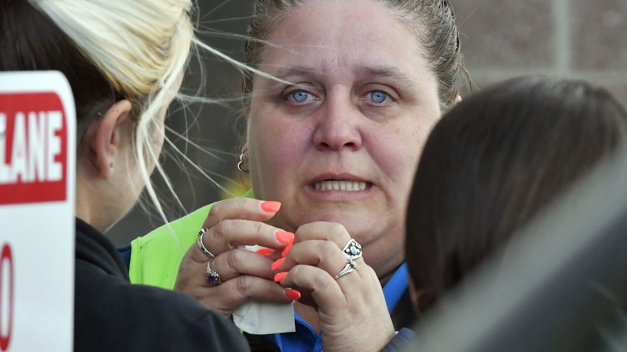 A Kroger employee wipes away tears following Wednesday's shooting in Jeffersontown, Kentucky, that left two people dead.