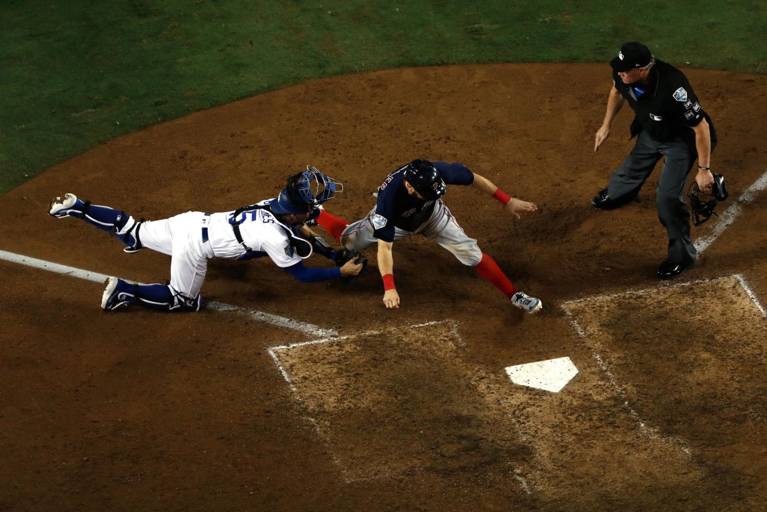 Ian Kinsler of the Red Sox is tagged out at home plate by Austin Barnes of the Dodgers on a throw from Cody Bellinger during the 10th inning of Game 3. The  Dodgers won in the 18th inning of a game that set the record as the longest in World Series history.