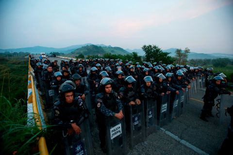Police in riot gear block the highway to stop a caravan of thousands of Central American migrants from advancing through Mexico on Saturday.