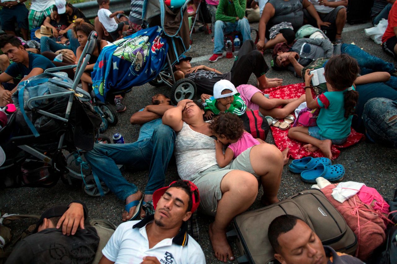 Migrants rest on a road between the Mexican states of Chiapas and Oaxaca after federal police briefly blocked them outside the town of Arriaga on Saturday, October 27.
