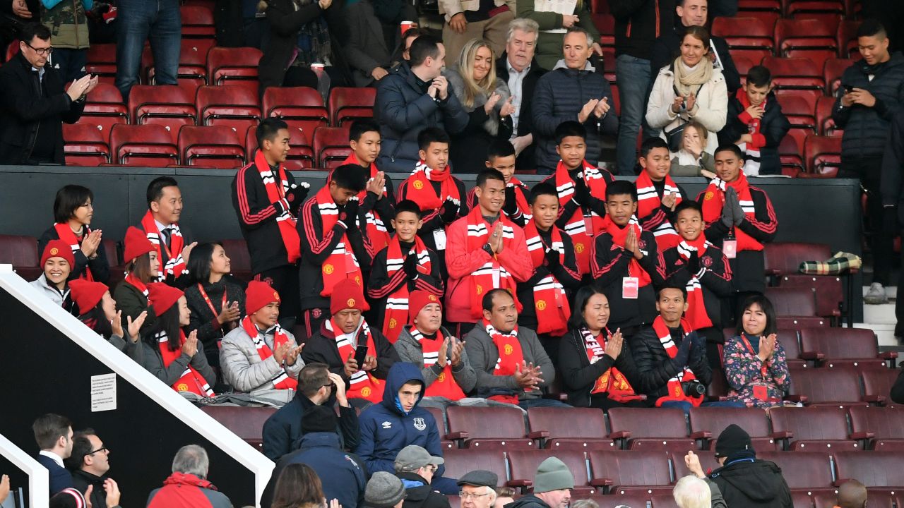 Players from the Moo Pa (Wild Boars) academy team are applauded by spectators at Old Trafford.