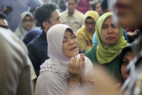 A woman in Pangkal Pinang prays as she and others wait for news on October 29.