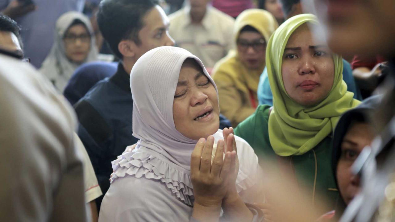 A relative of passengers prays as she and others wait for news on the Lion Air plane.