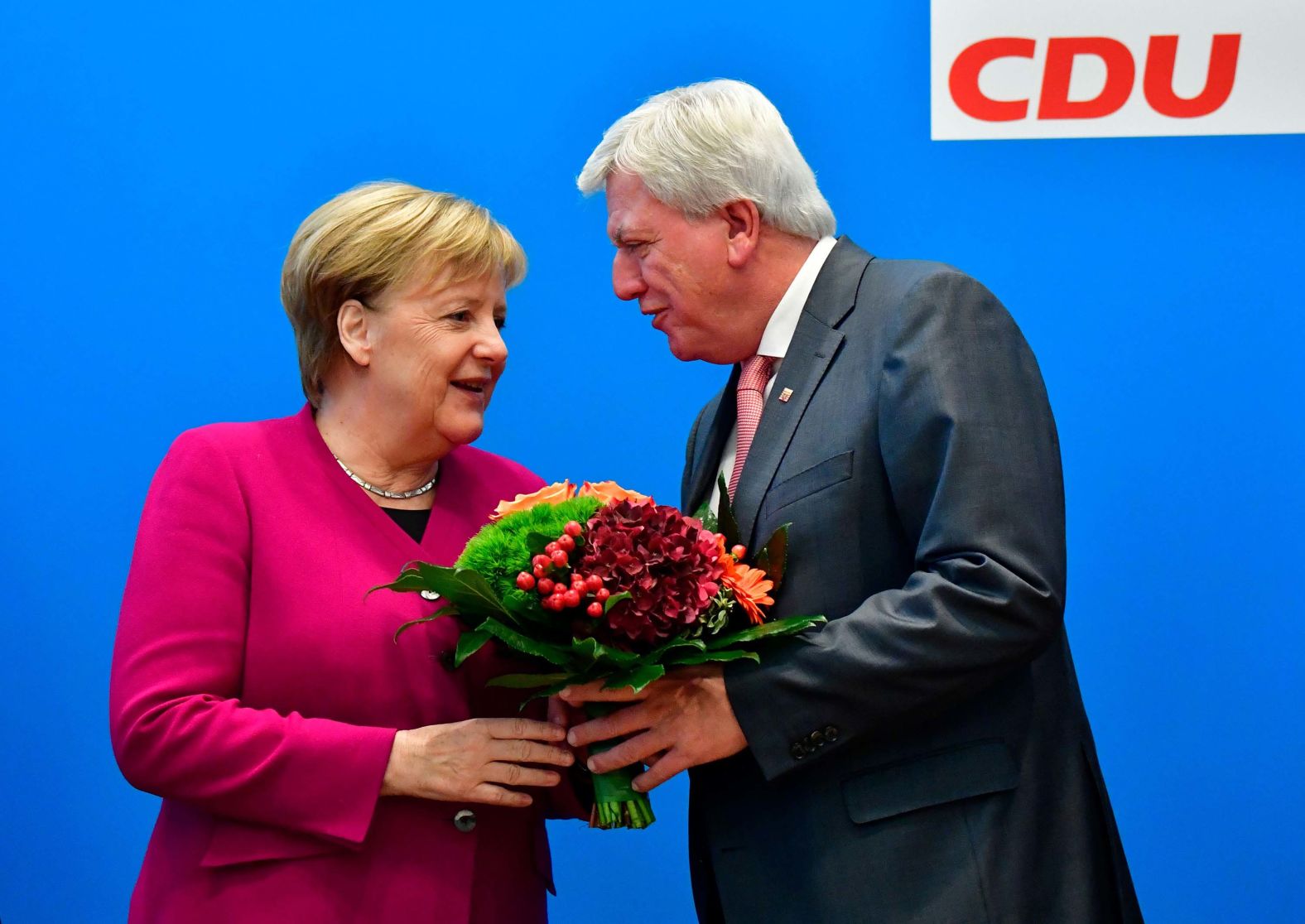 Merkel offers flowers to Volker Bouffier, the state premier of Hesse and the deputy chairman of the Christian Democratic Union, ahead of a party leadership meeting in October 2018. The day before, her coalition government suffered heavy losses in a key regional election in Hesse.