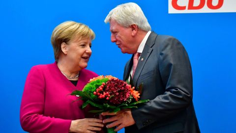 Merkel offers flowers to Volker Bouffier, the state premier of Hesse and the deputy chairman of the Christian Democratic Union, ahead of a party leadership meeting in October 2018. The day before, her coalition government suffered heavy losses in a key regional election in Hesse.