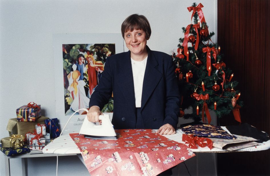 Merkel, as the country's leader on environmental issues, irons wrapping paper to show how it can be recycled.