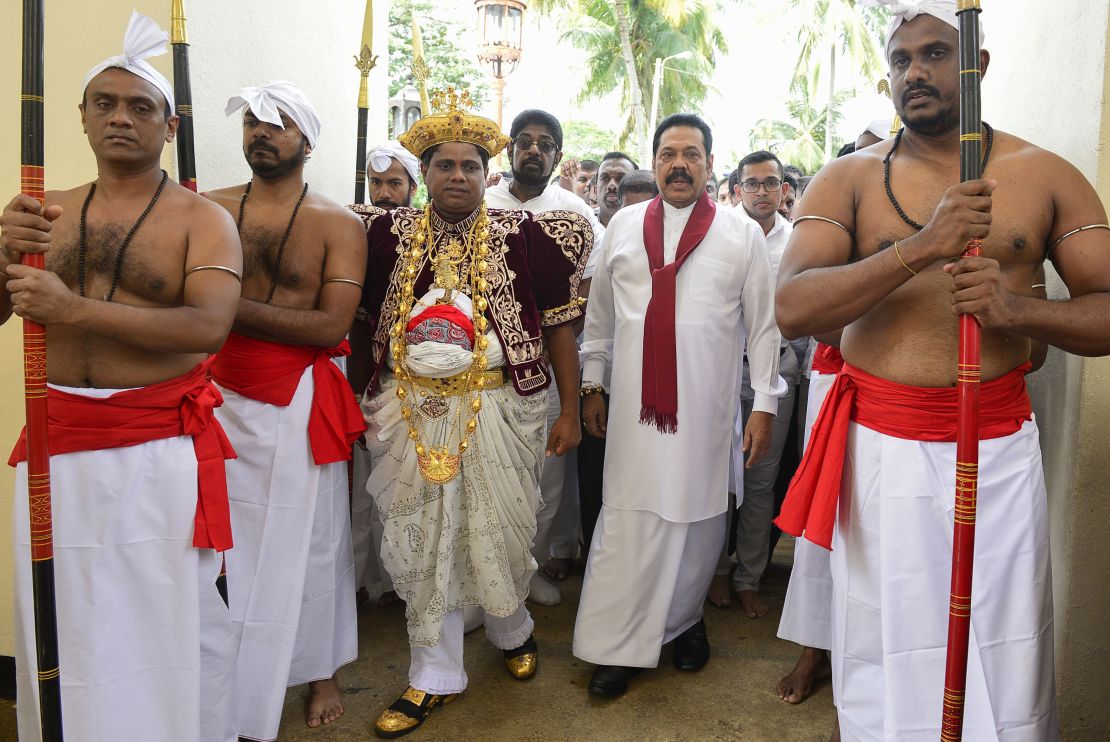Sri Lanka's former president and new prime minister Mahinda Rajapakse (2R) arrives at the Temple of the Sacred Tooth Relic in Kandy on October 28, 2018.